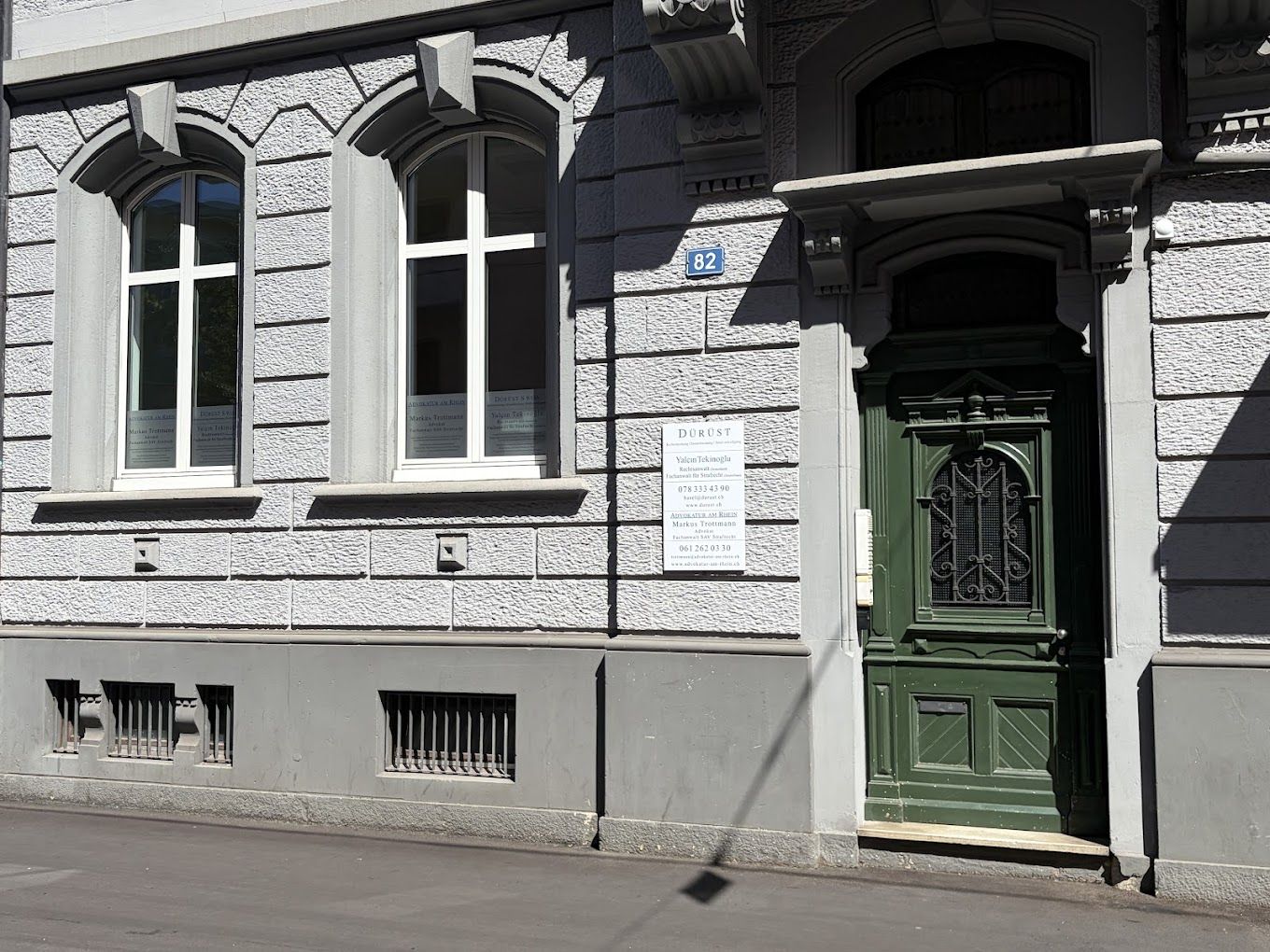 Basel’deki büronun girişi, büro tabelası ve yeşil ahşap kapı